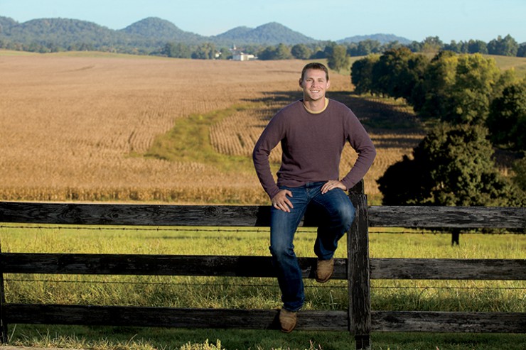 Quint Pottinger sits on a fence overlooking his corn fields which are almost ready for harvest on his farm in New Haven, Kentucky.