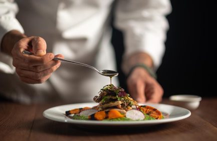 chef preparing plate at farm-to-table restaurant