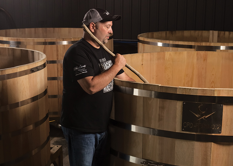 Brian Call prepares some 1,000-gallon mash barrels while distilling moonshine. 