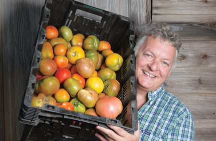 Richard Holcomb of Coon Rock Farm in Hillsborough, N.C., holds fresh heirloom tomatoes grown on the farm’s land.