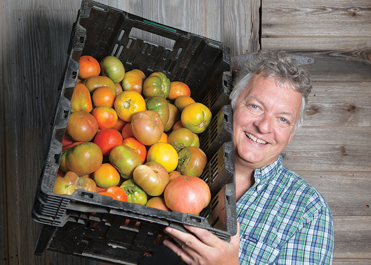 Richard Holcomb of Coon Rock Farm in Hillsborough, N.C., holds fresh heirloom tomatoes grown on the farm’s land.