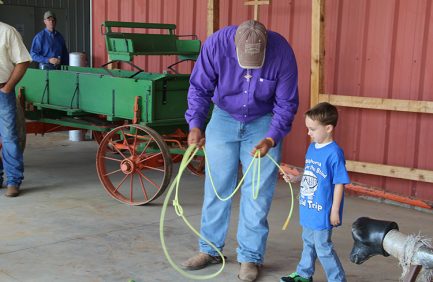 Connor Osborn, sophomore calf and team roper from Tecumseh, Okla., teaches the ropes to a young OSFB student.