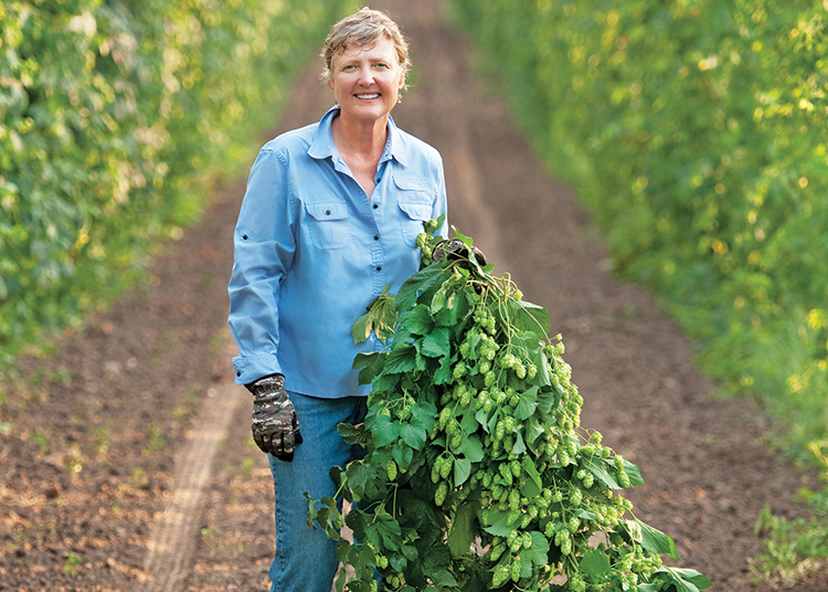 Gayle Goschie of Goschie Farms holds hops.