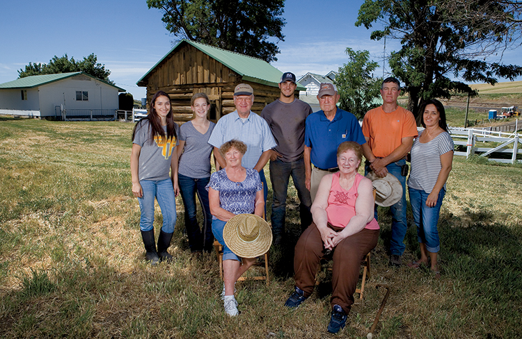 The Lieuallen family poses in front of the original cabin on their Adams farm