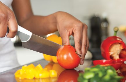 Prep cook slicing tomato and peppers