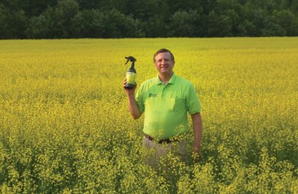 Don Kettles stands in a field holding a Superzilla product