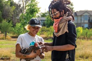 JaSon Auguste petting a chicken at FrontLine Farm