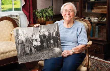 Eleanor Arnold holds a black and white photo of the Arnold family