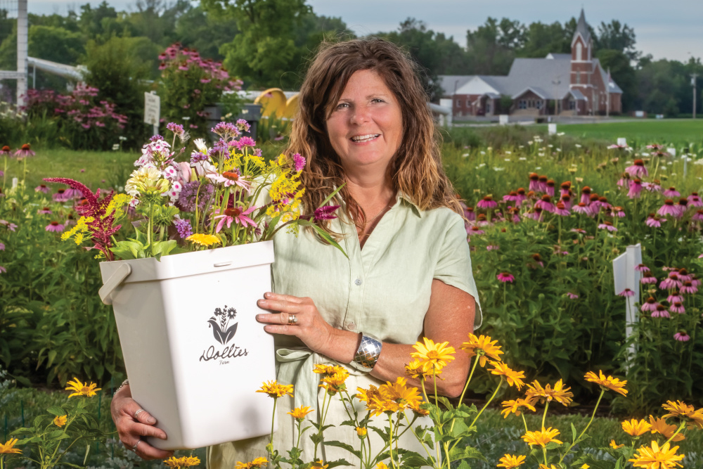 Tricia Wilson holding a bucket of flowers at her Indiana flower farm, Dollie's Farm