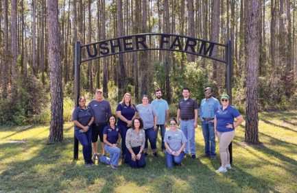 Agriscience Education Leadership Program participants and leaders pose for a photo in front of the Usher Farms sign